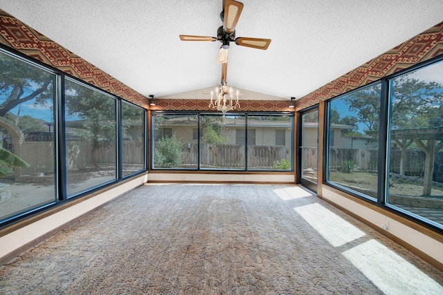 unfurnished sunroom with ceiling fan with notable chandelier and vaulted ceiling