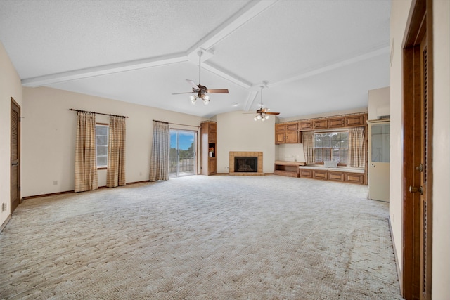 110 Monroe St, Giddings, TX 78942 - unfurnished living room with light carpet, vaulted ceiling with beams, a fireplace with raised hearth, and a ceiling fan