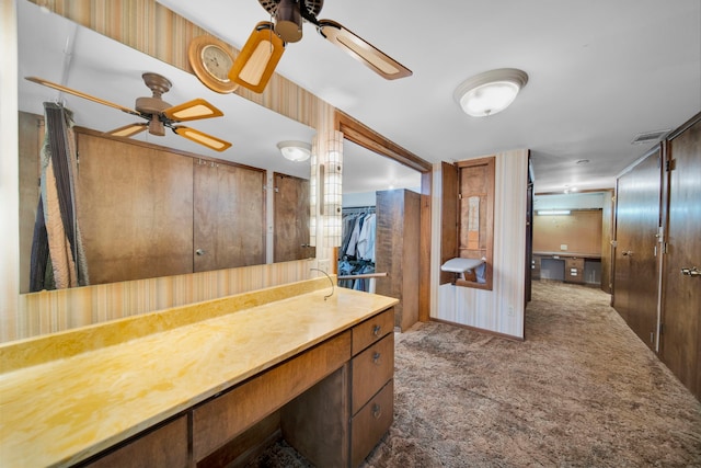 bathroom with wood walls, vanity, and ceiling fan