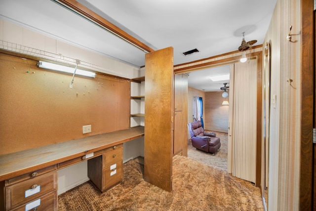 interior space featuring built in desk and ceiling fan