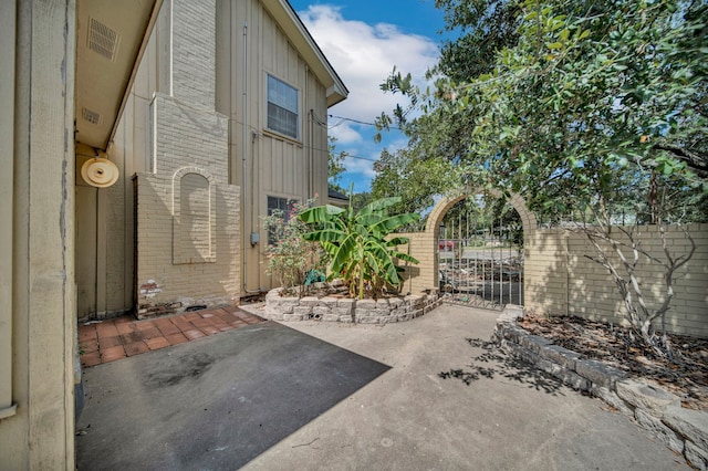 110 Monroe St, Giddings, TX 78942 - view of side of property with brick siding, fence, a patio, and a gate