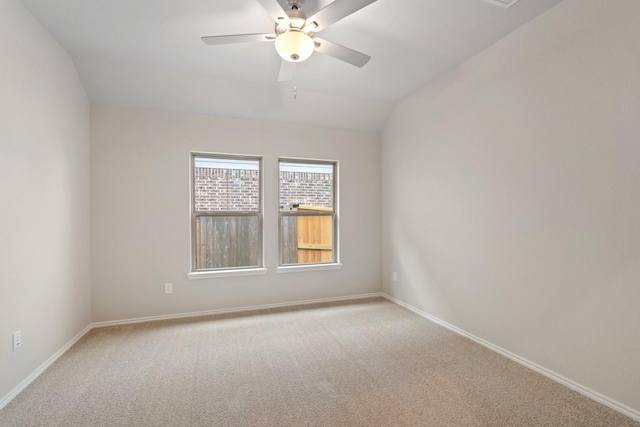 empty room with vaulted ceiling, baseboards, a ceiling fan, and light colored carpet