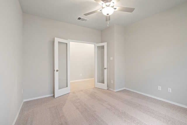 unfurnished room featuring light colored carpet, french doors, visible vents, and baseboards