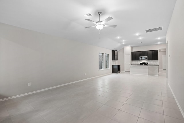 unfurnished living room featuring lofted ceiling, light tile patterned floors, ceiling fan, and visible vents