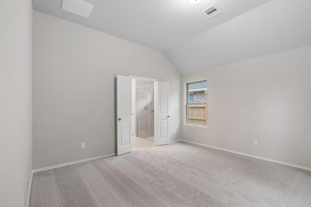 unfurnished bedroom featuring lofted ceiling, carpet flooring, visible vents, and baseboards