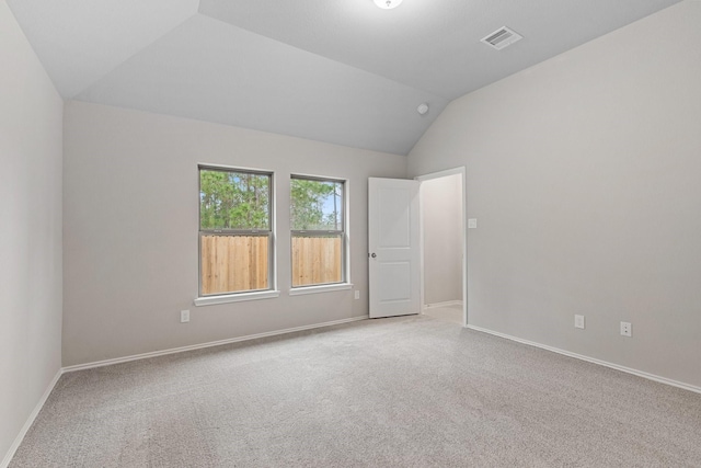 carpeted empty room with vaulted ceiling, visible vents, and baseboards