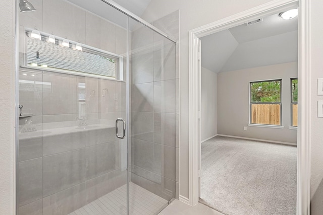 bathroom with lofted ceiling, a shower stall, visible vents, and baseboards