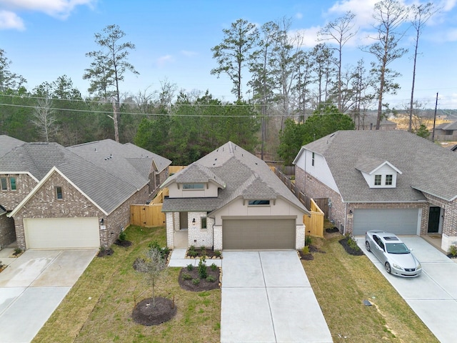 view of front facade with concrete driveway, brick siding, a front yard, and a shingled roof