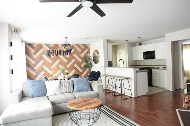 living room with ceiling fan, sink, and dark hardwood / wood-style flooring