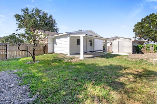 rear view of house with a storage shed, a lawn, and a patio