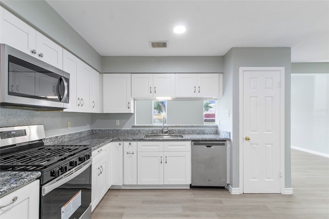 kitchen featuring white cabinets, stainless steel appliances, and light hardwood / wood-style flooring