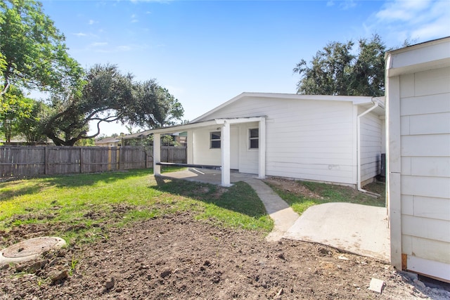 rear view of house with a lawn and a patio area