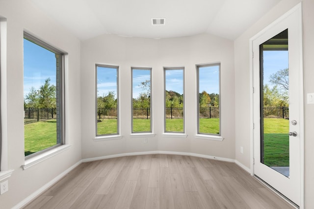 unfurnished sunroom featuring a healthy amount of sunlight and vaulted ceiling