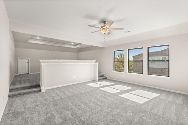 carpeted spare room featuring ceiling fan and a tray ceiling