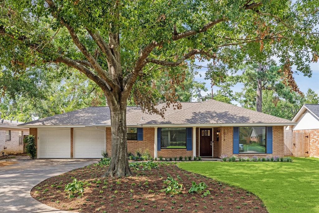 ranch-style house featuring a garage and a front lawn