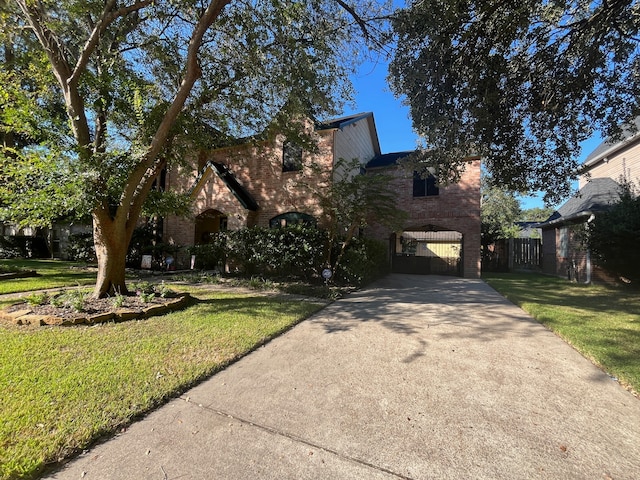 view of front facade with brick siding, concrete driveway, and a front yard