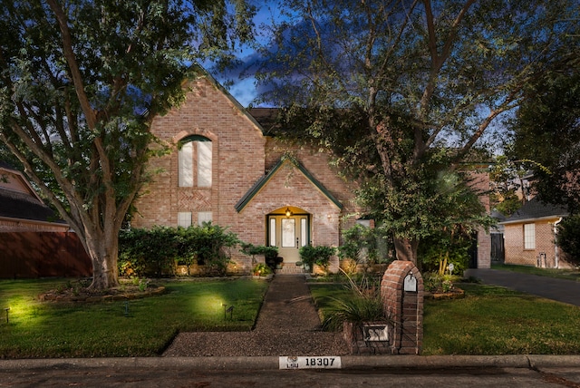 view of front of home with driveway, a garage, a front lawn, and brick siding