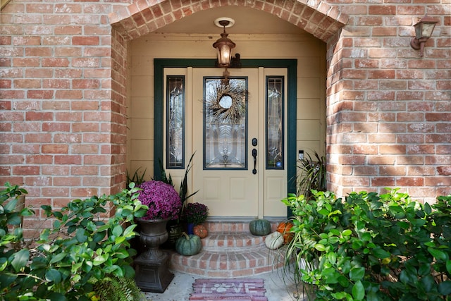 view of exterior entry featuring brick siding