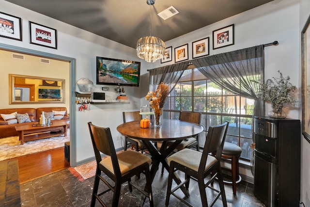 dining space featuring baseboards, visible vents, and a notable chandelier