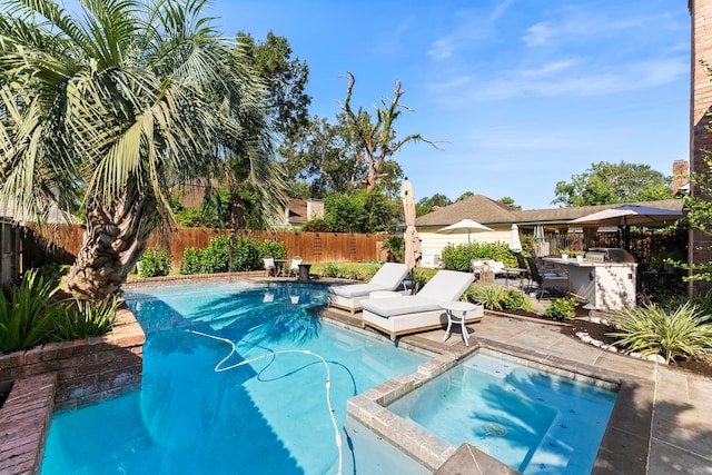 view of swimming pool featuring a fenced backyard, a patio, an outdoor bar, and area for grilling