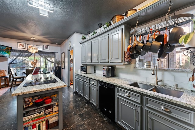 kitchen with black appliances, light stone counters, a sink, and gray cabinetry