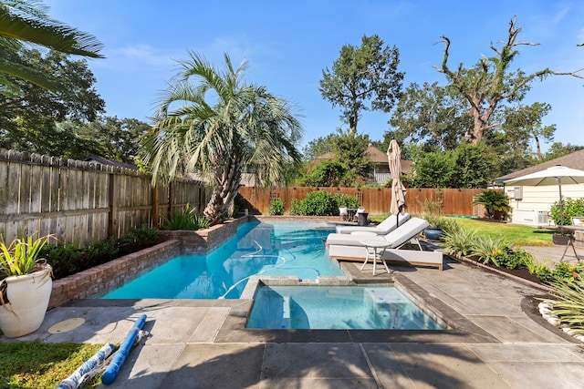 view of pool featuring a pool with connected hot tub, a fenced backyard, and a patio