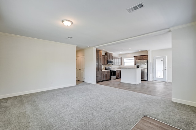 unfurnished living room featuring ornamental molding and light colored carpet