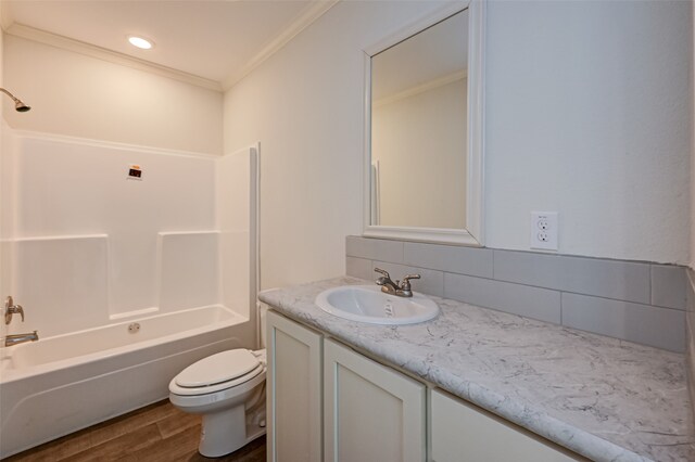 full bathroom featuring vanity, hardwood / wood-style flooring, bathing tub / shower combination, crown molding, and toilet