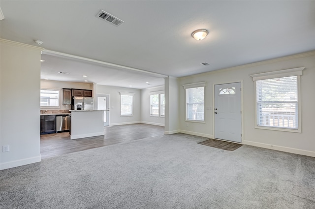 carpeted foyer entrance with ornamental molding