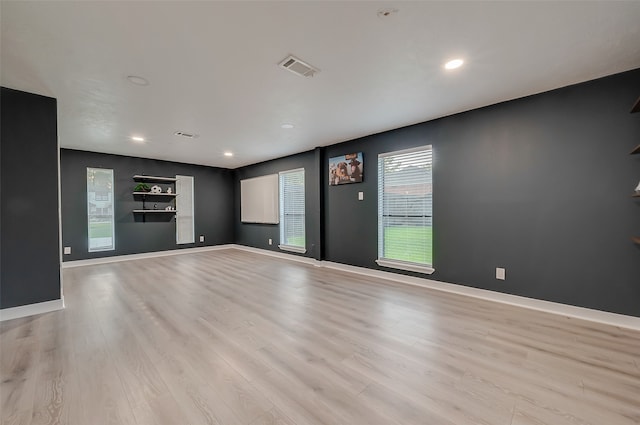 empty room with light wood-type flooring and a wealth of natural light