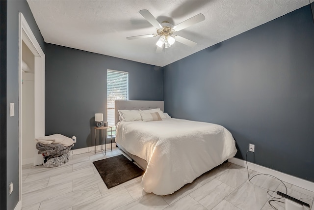 bedroom featuring a textured ceiling and ceiling fan