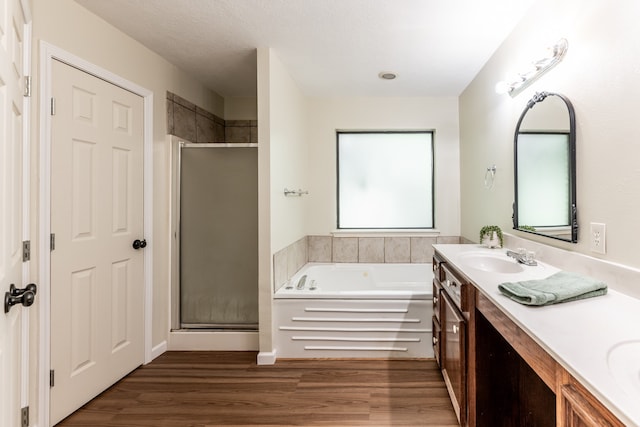 bathroom featuring a textured ceiling, vanity, separate shower and tub, and hardwood / wood-style flooring