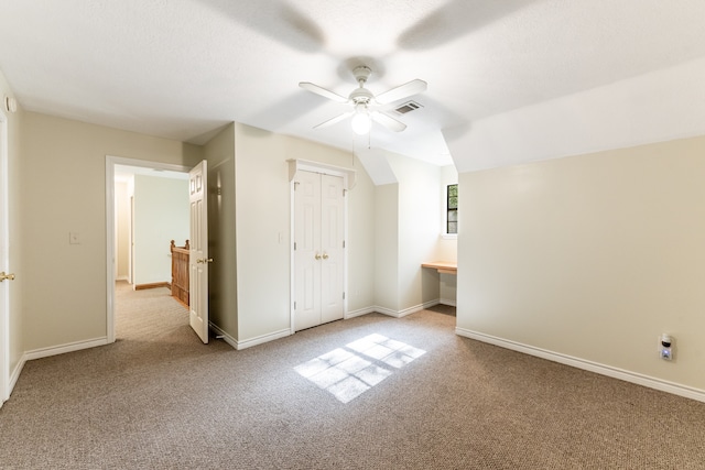 interior space with light carpet, a closet, lofted ceiling, and ceiling fan