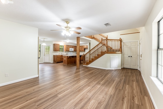 interior space with light wood-type flooring, ceiling fan, and plenty of natural light