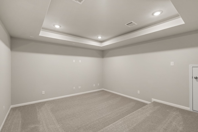 carpeted spare room with a tray ceiling