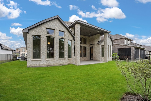 rear view of property with a patio area, central AC, and a lawn