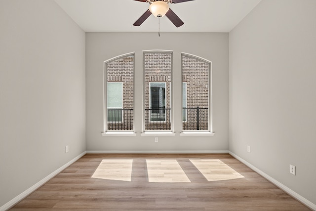 unfurnished room with ceiling fan, a wealth of natural light, and light wood-type flooring