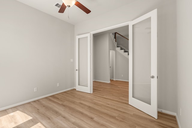 unfurnished bedroom featuring ceiling fan, a closet, light hardwood / wood-style floors, and french doors