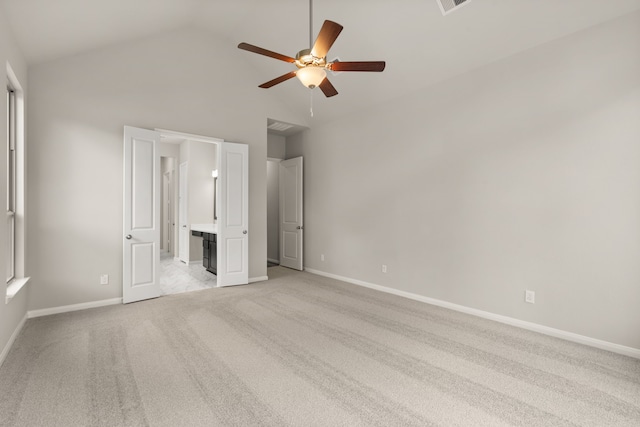 unfurnished bedroom with ceiling fan, light colored carpet, high vaulted ceiling, and ensuite bath