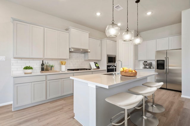 kitchen featuring stainless steel appliances, light countertops, and white cabinets