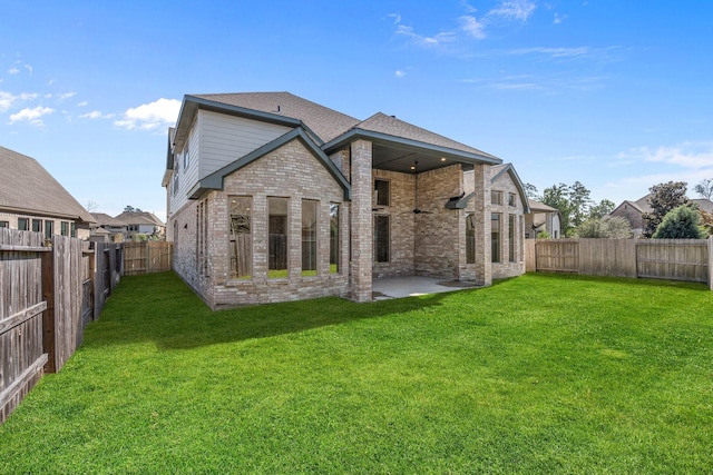 rear view of house featuring a fenced backyard, roof with shingles, a lawn, and brick siding