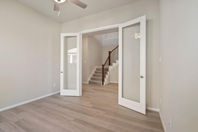 unfurnished room with light wood-style floors, stairs, baseboards, and french doors