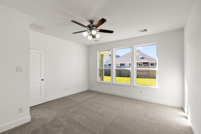 carpeted spare room featuring ceiling fan