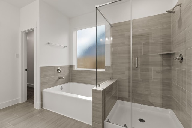 bathroom featuring separate shower and tub and plenty of natural light