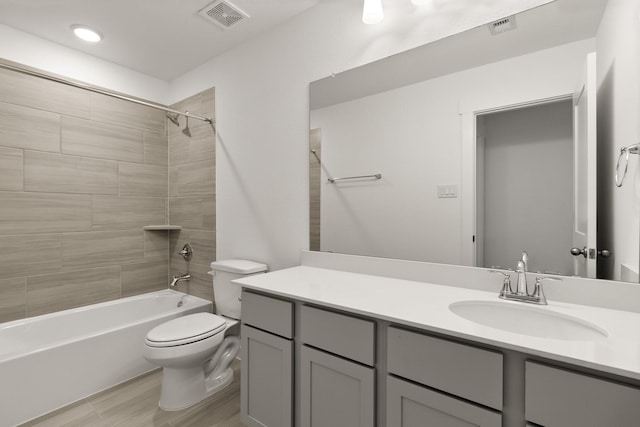 full bathroom with hardwood / wood-style floors, vanity, toilet, and tiled shower / bath combo