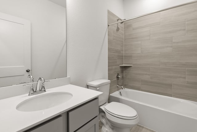 full bathroom with vanity, tiled shower / bath combo, and toilet