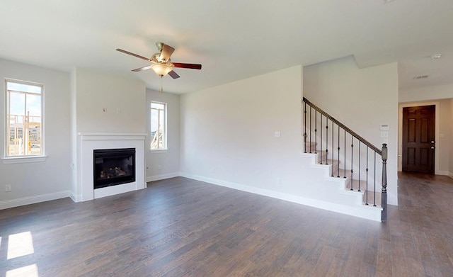 unfurnished living room with ceiling fan and dark wood-type flooring