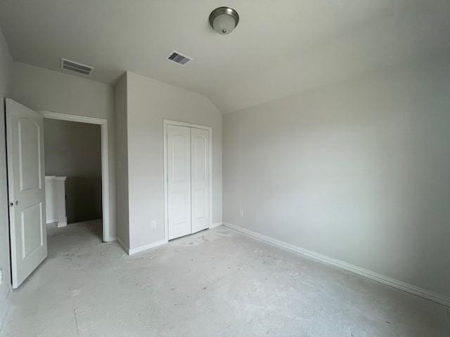 unfurnished bedroom with vaulted ceiling and a closet