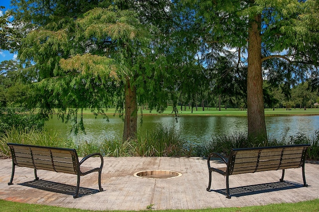 view of home's community with a water view and an outdoor fire pit