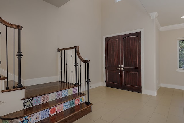 foyer entrance with ornamental molding and a high ceiling